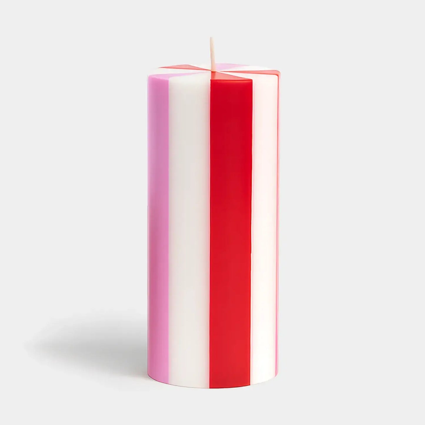 Striped red, white, and pink candle on a light gray background