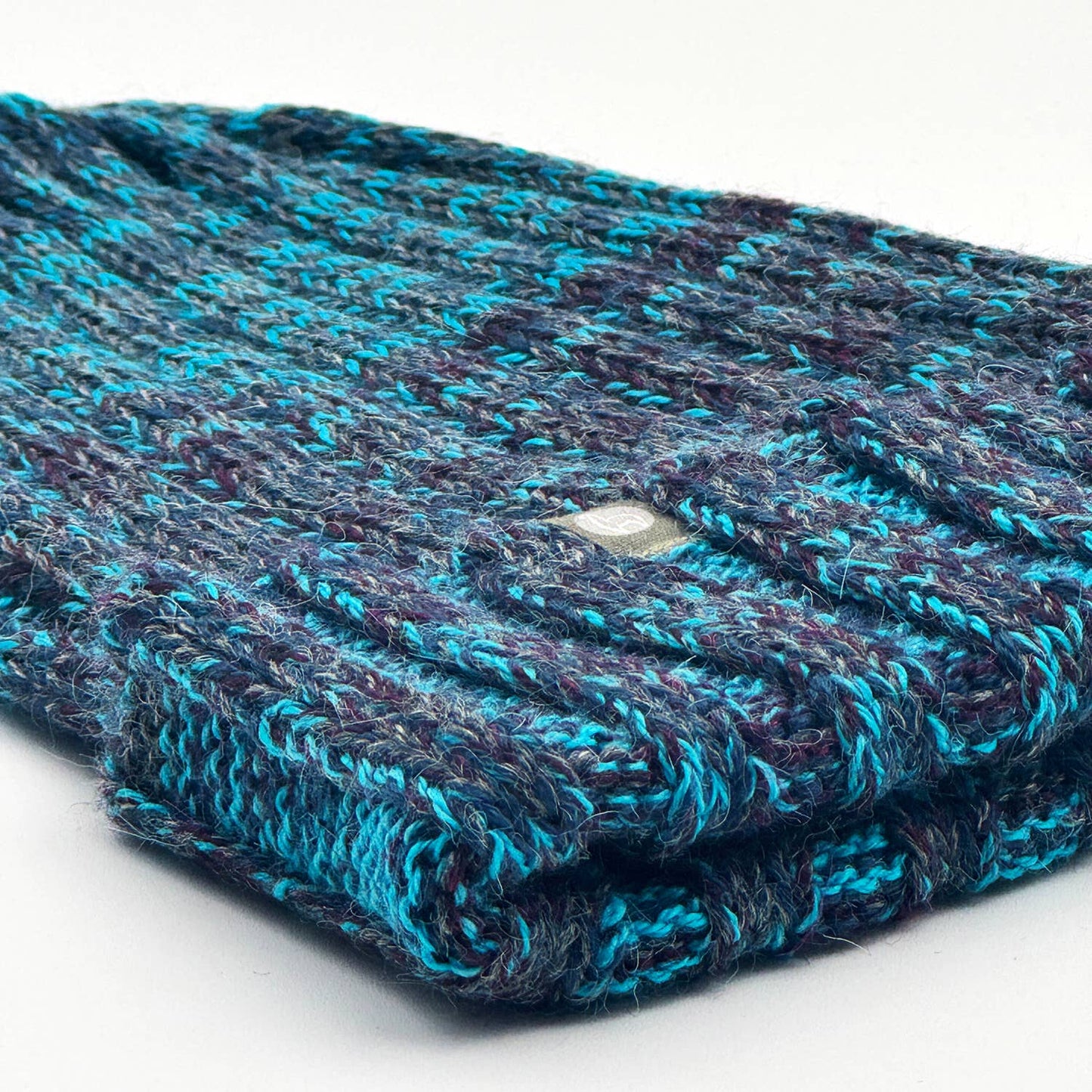 Folded knitted fabric with blue and purple pattern on a white background