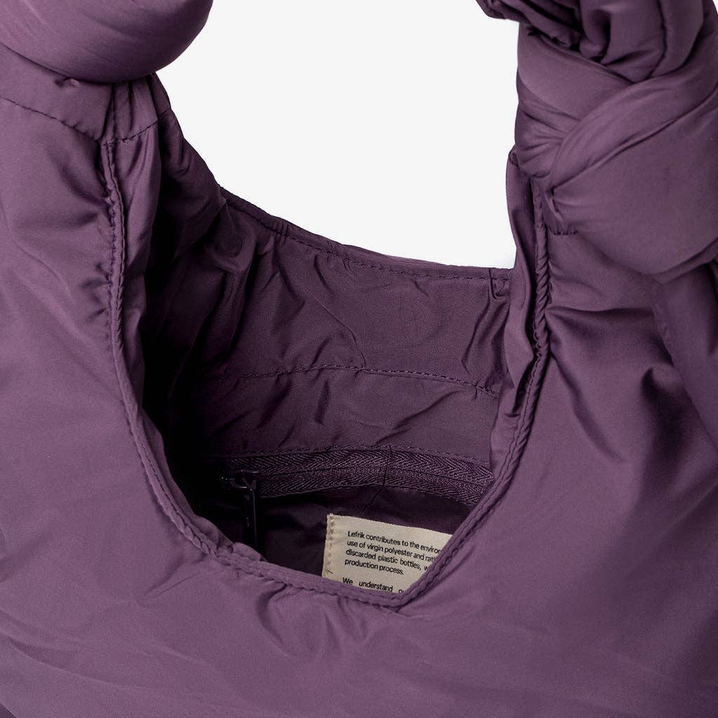 Close-up of a purple garment with a visible label on a white background