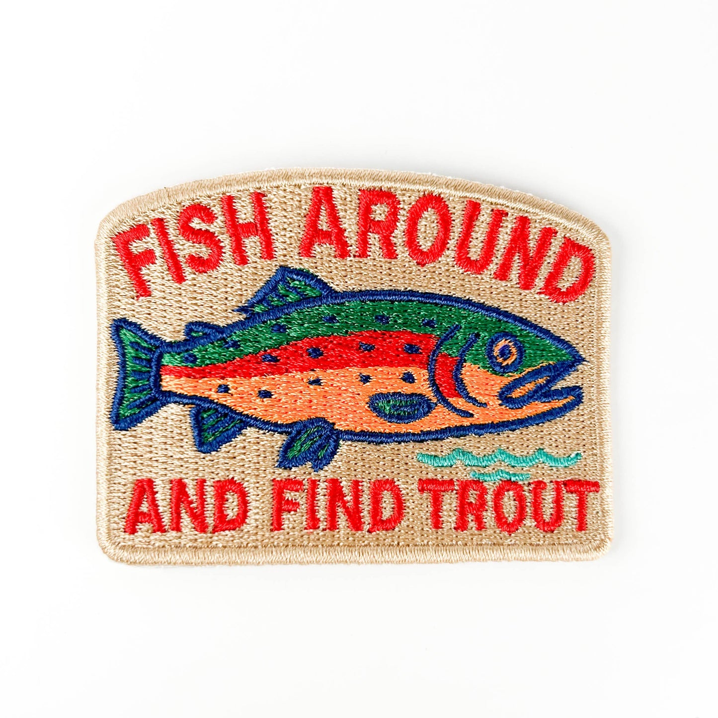 Embroidered patch with a fish and text 'Fish Around and Find Trout' on a beige background
