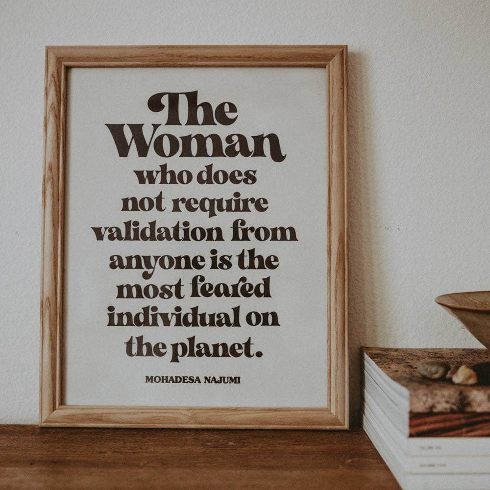 Framed quote by Mohandas K. Gandhi on a wooden surface with a neutral background