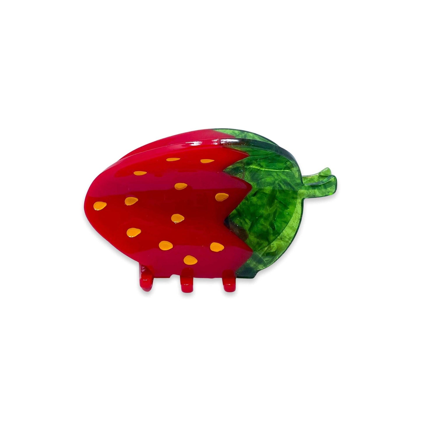 Strawberry-shaped hair clip with red body and green leaves on a white background