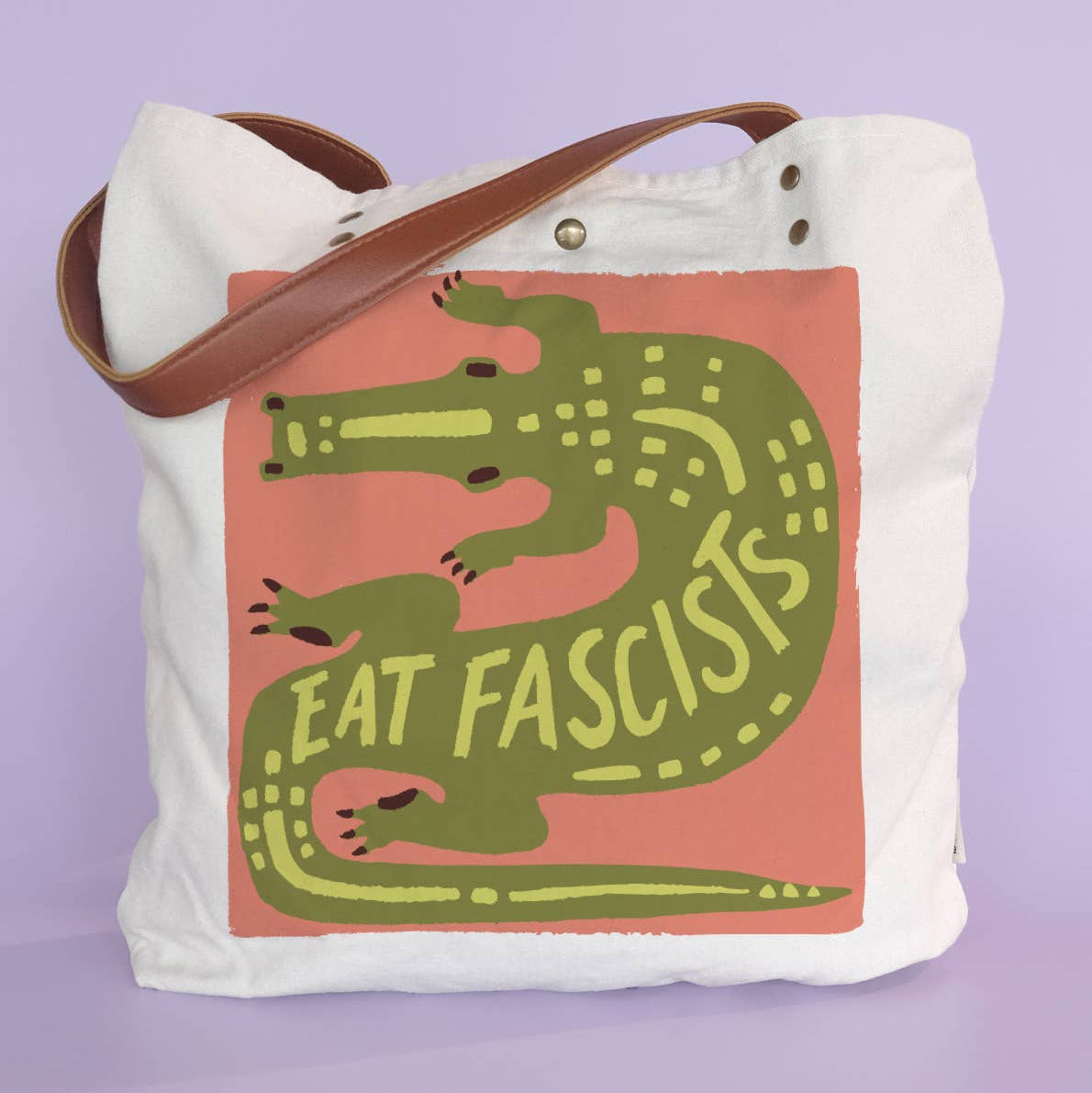 Tote bag with alligator graphic and 'Eat Fascists' text on a purple background
