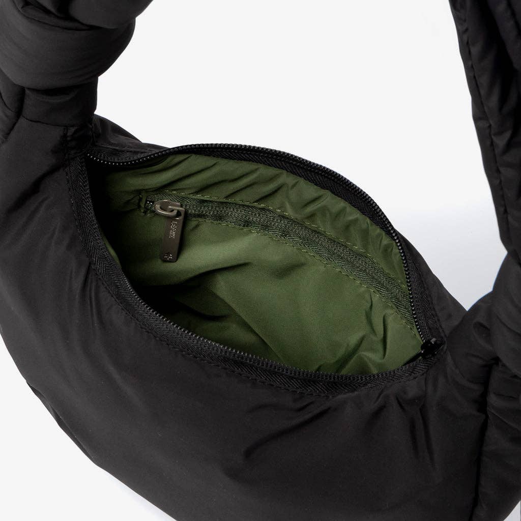 Close-up of a black jacket with green lining on a white background