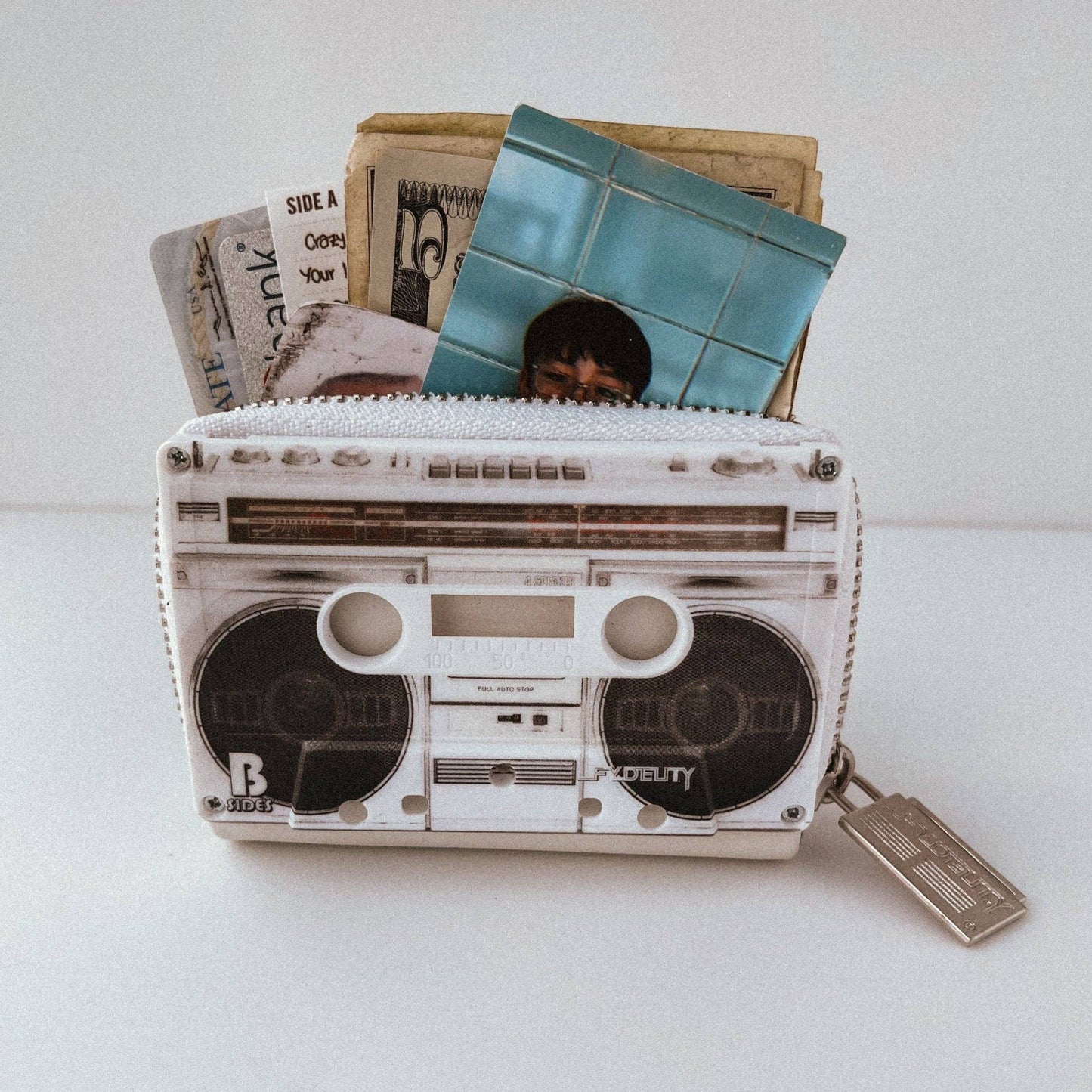 Boxy wallet designed like a vintage boombox with photos and money on a white background
