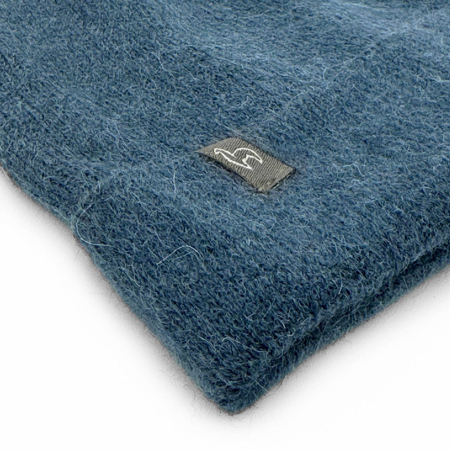 Blue textured fabric with a brand logo on a white background
