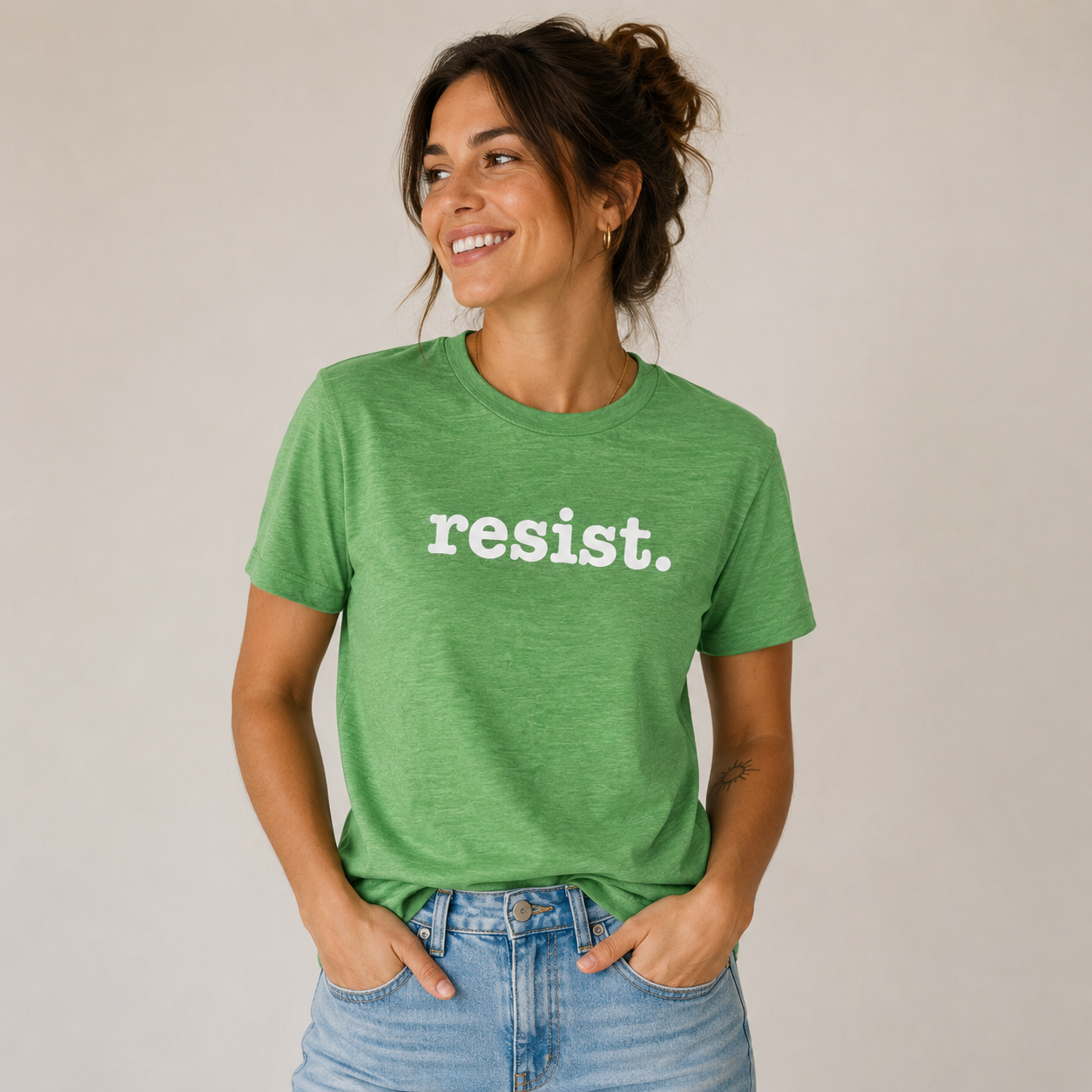 Woman wearing a green t-shirt with 'resist.' text on a plain background