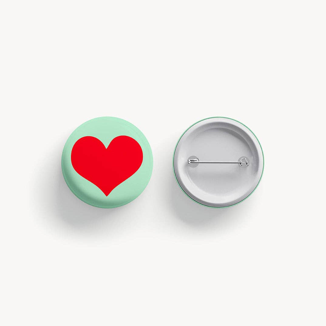 Button badge with a red heart on a white background