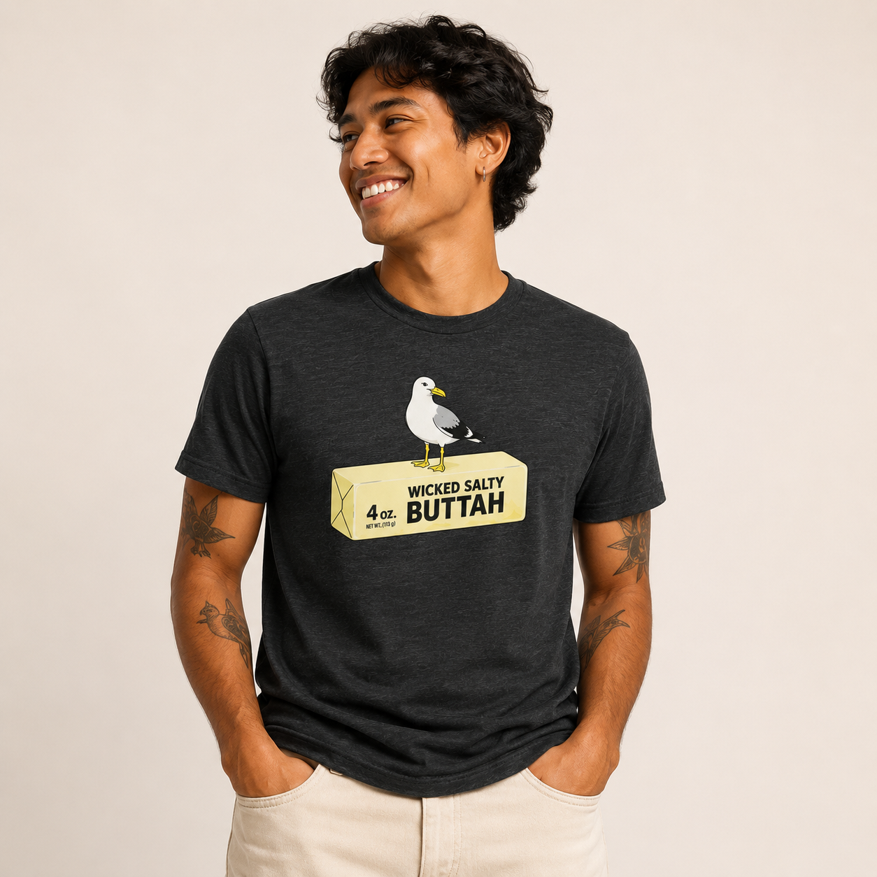 Person wearing a black t-shirt with a graphic of a seagull and text on a beige background