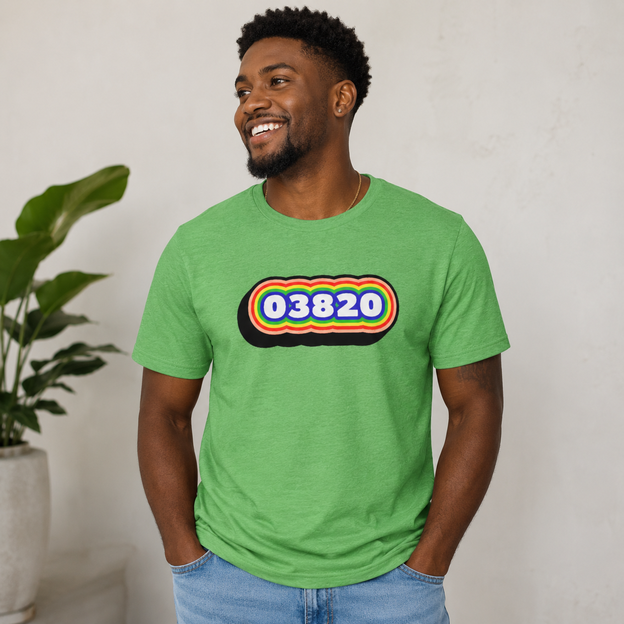 Man wearing a green t-shirt with a colorful design and text, standing against a plain background.