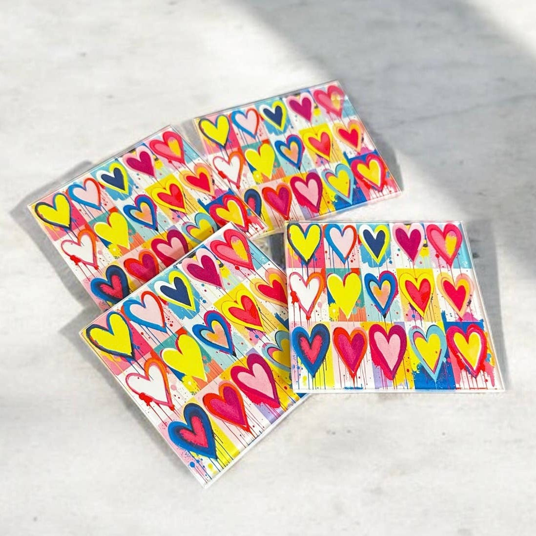 Set of colorful heart-shaped stickers on a light gray surface