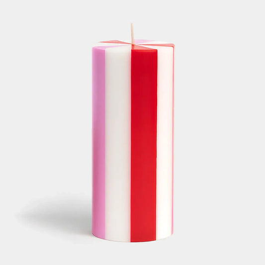 Striped red, white, and pink candle on a light gray background