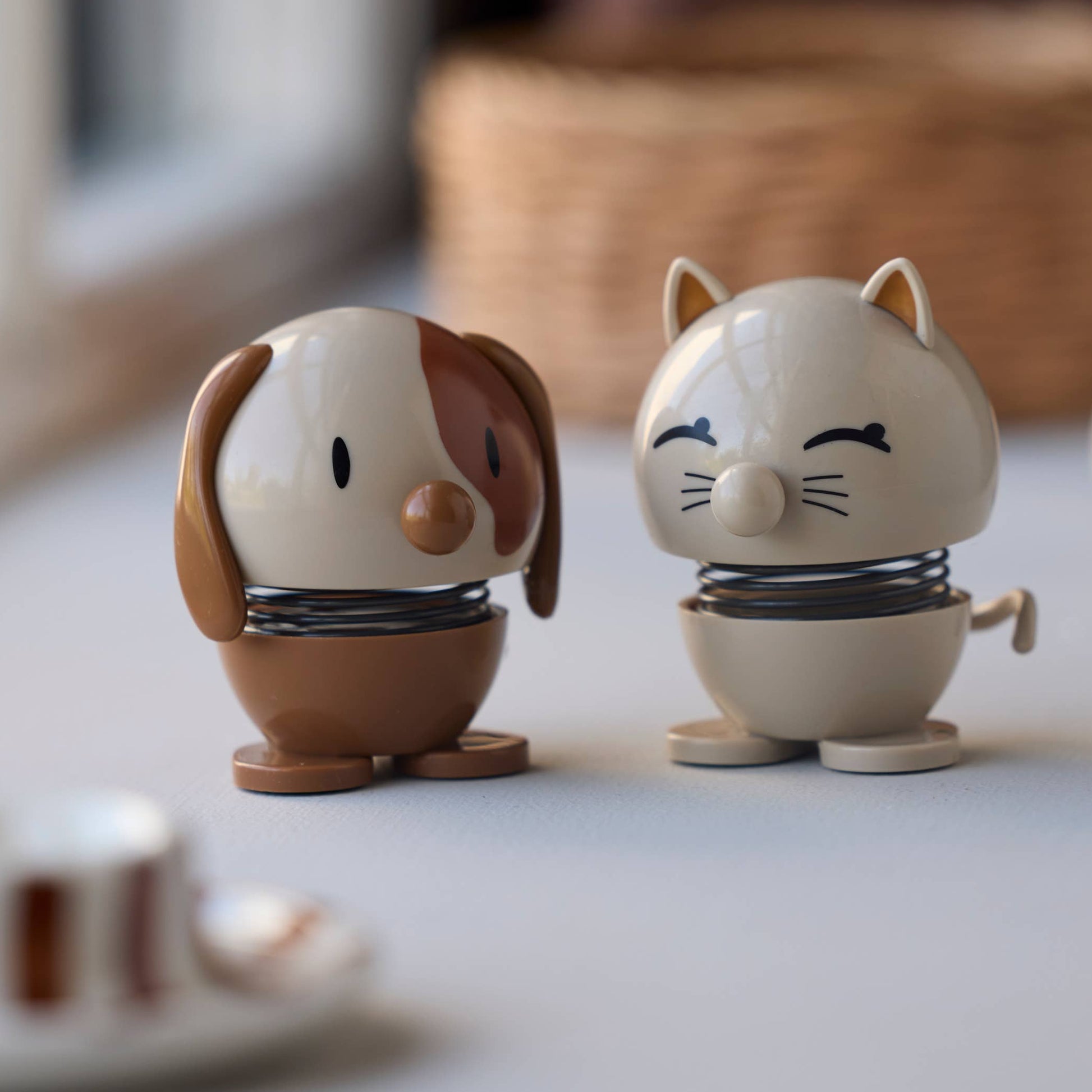 Two small animal figurines on a surface with a window in the background