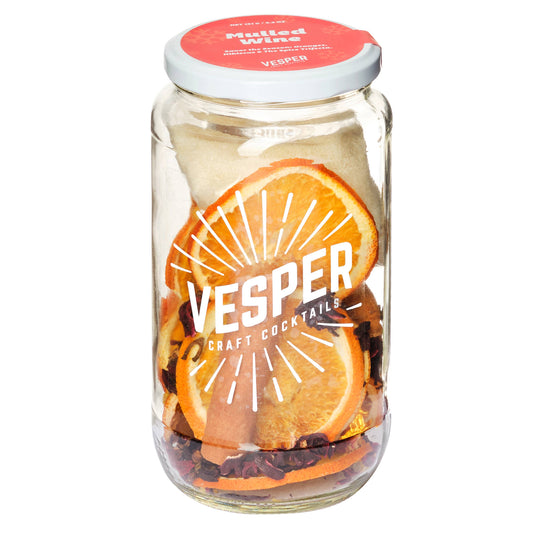 Vesper craft cocktail jar with orange slices and dried fruits on a white background