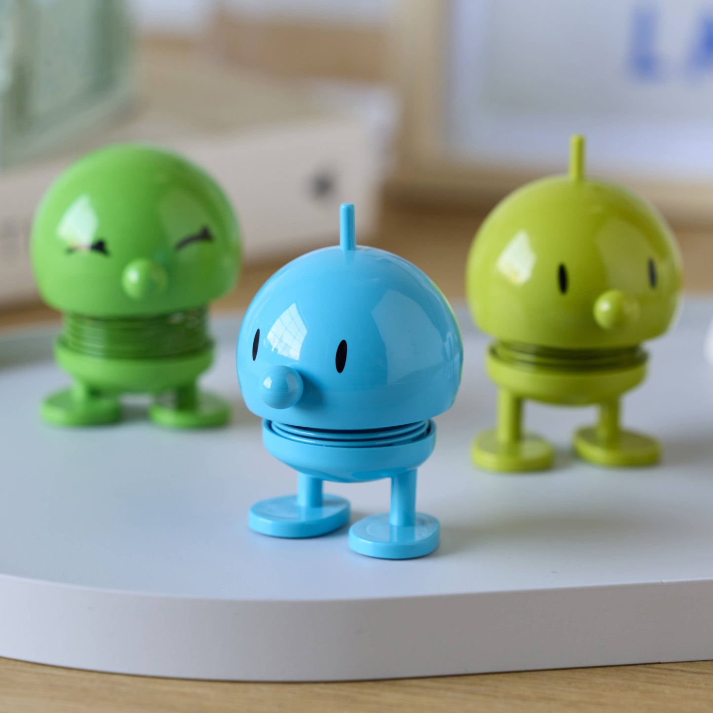 Three colorful toy figures on a white surface with a blurred background