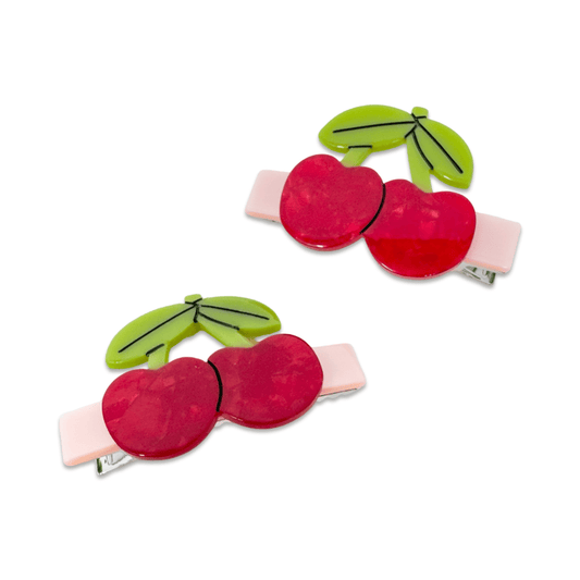 Two red cherry-shaped hair clips with green leaves on a white background