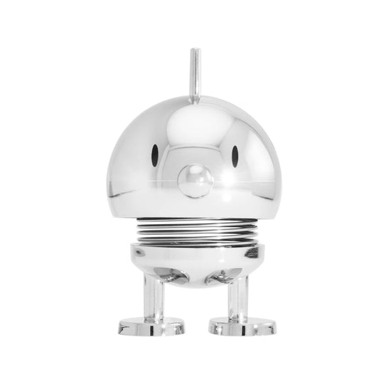 A small metallic silver robot figurine with a glossy chrome finish, standing on two tiny legs against a solid white background.