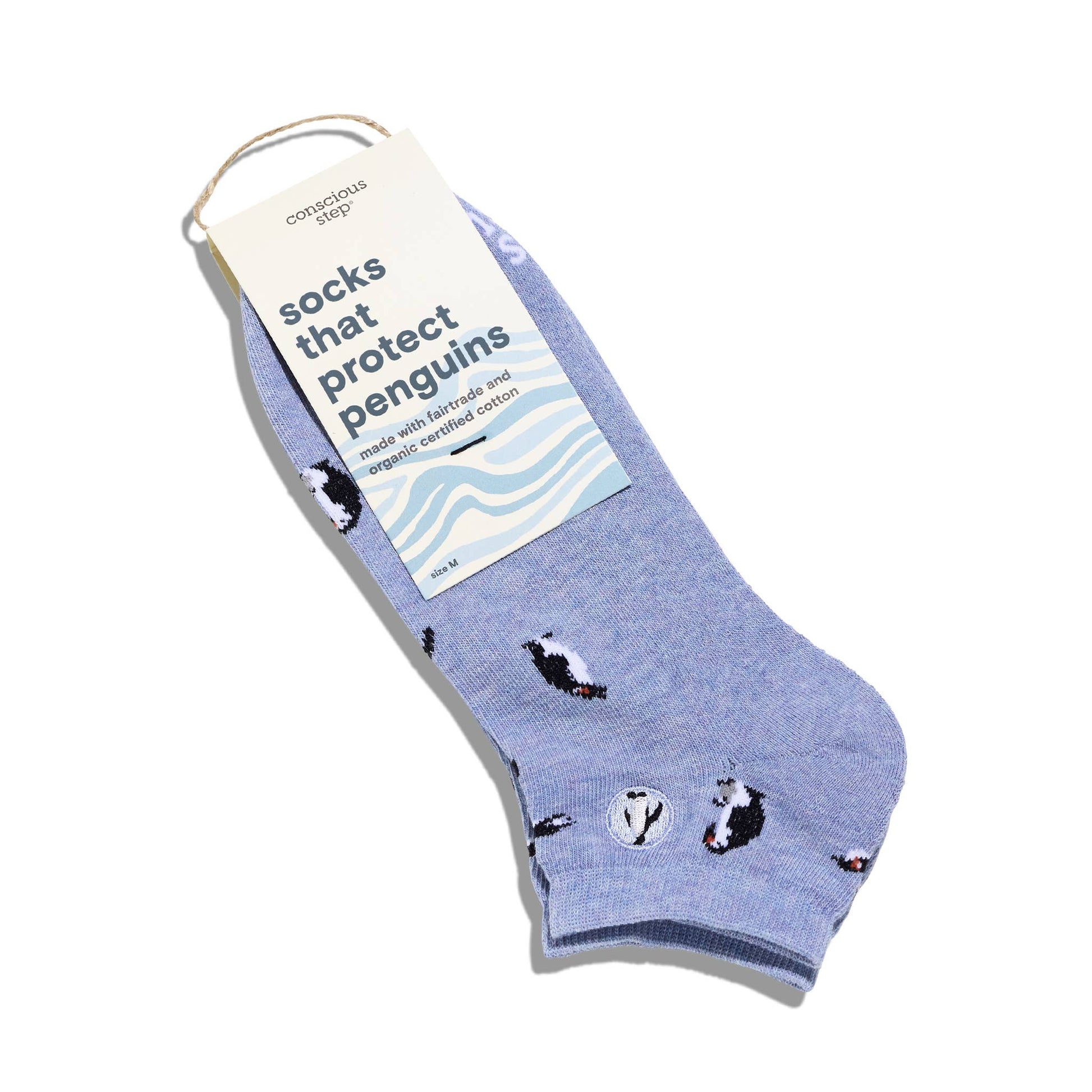 Blue sock with penguin design and 'conscious step' label on a white background