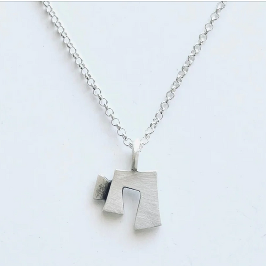 Silver necklace with a unique pendant on a light gray background