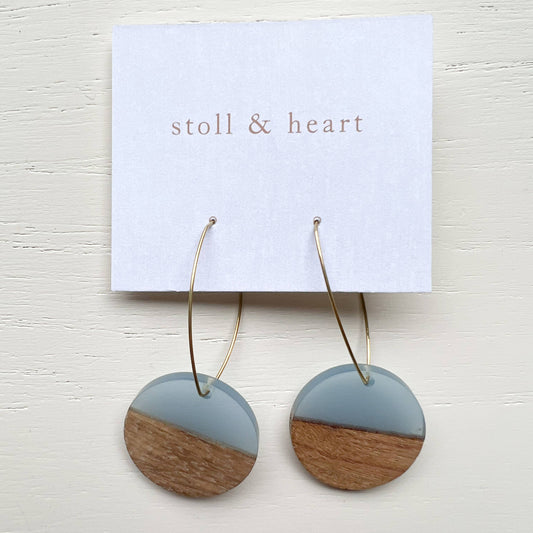 Wooden earrings with a two-tone design on a 'stoll & heart' branded card.