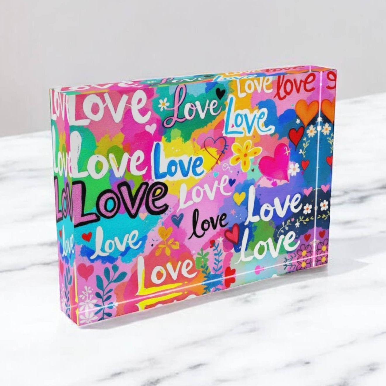Colorful box with 'love' text and designs on a marble surface