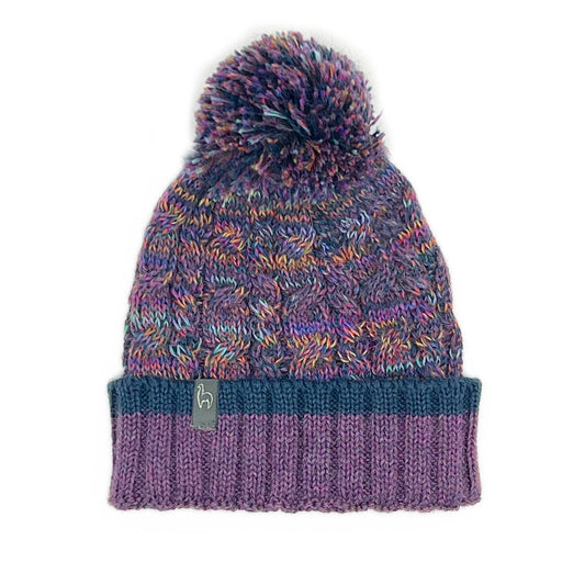Multicolored knit beanie with a pom-pom on a white background