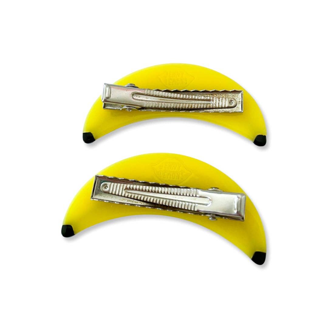 Two banana-shaped hair clips with metal clips on a white background