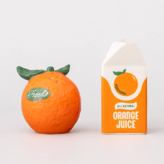 Orange-shaped container with green leaves and a box of orange juice on a white background