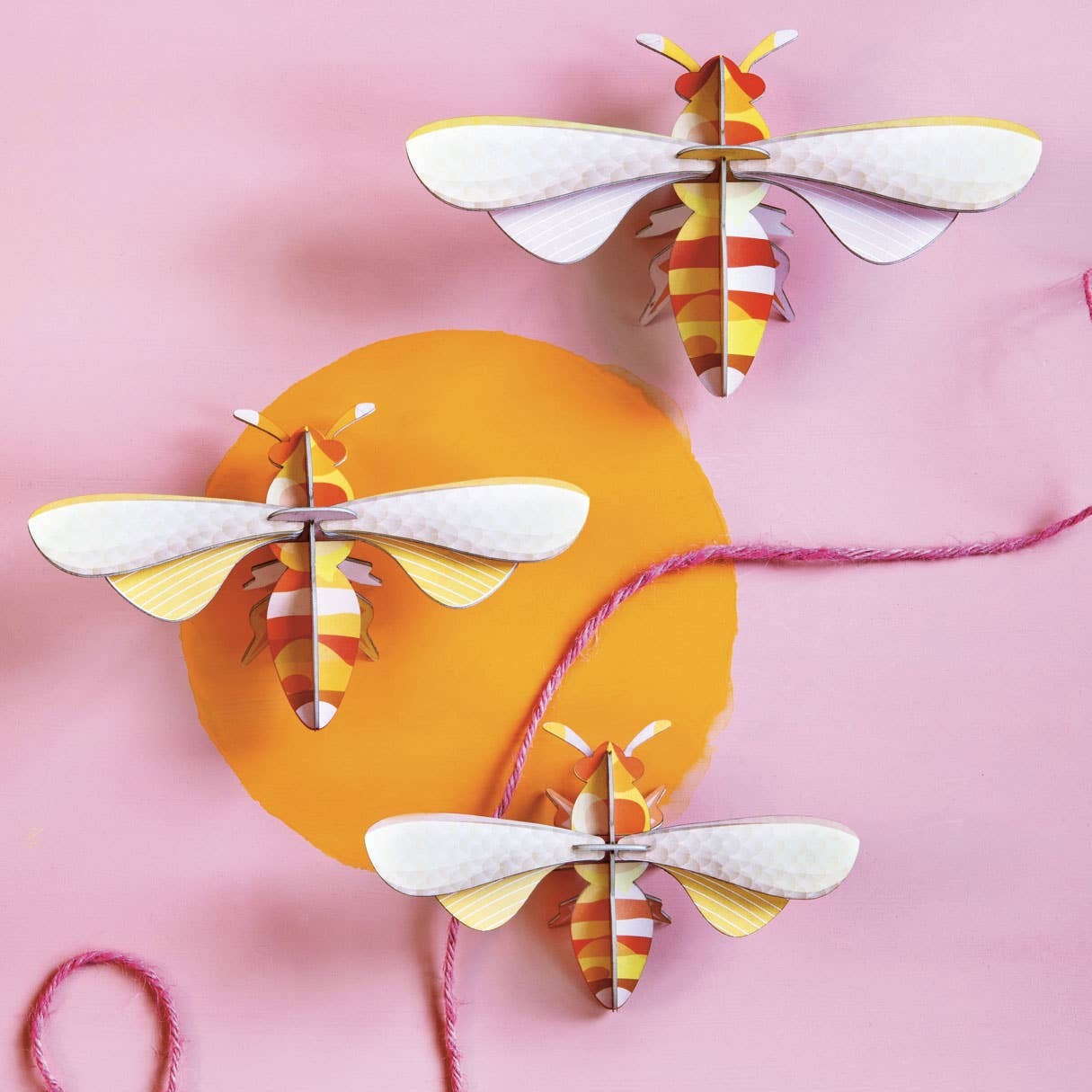 Colorful paper moths on a pink background