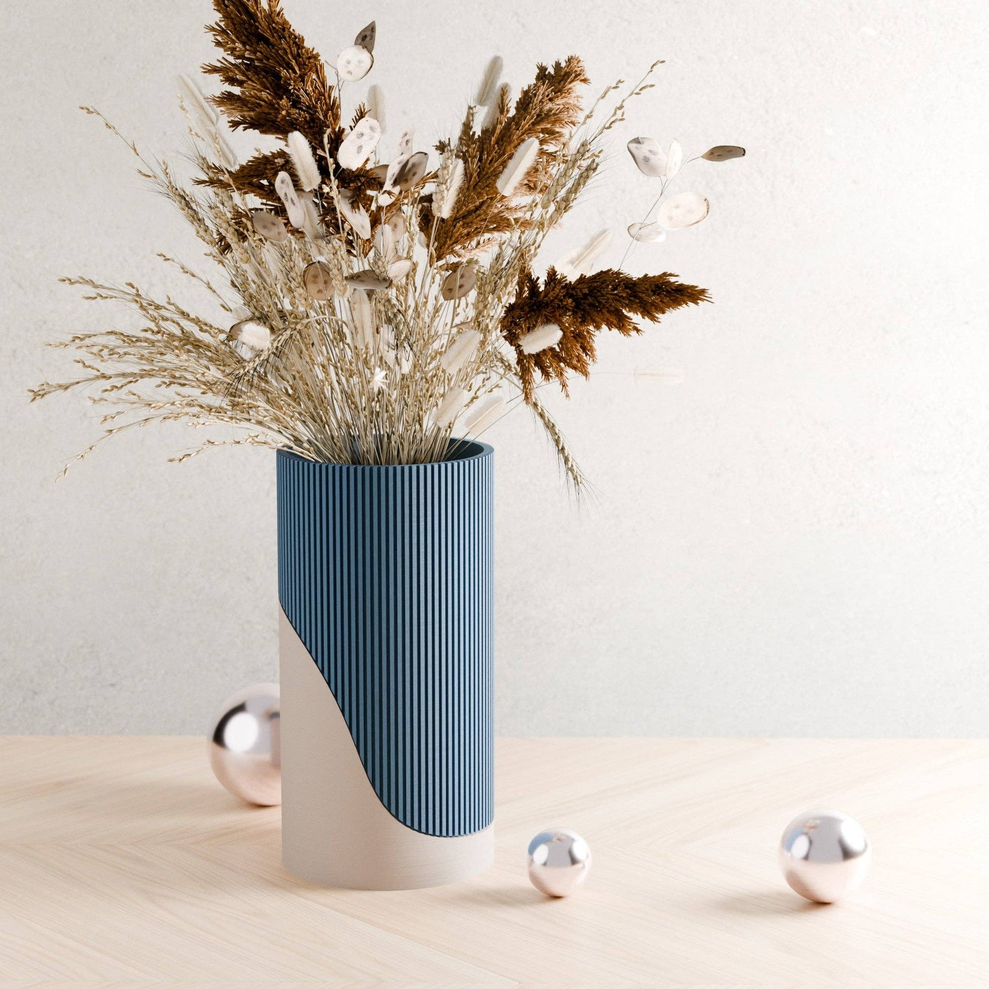 Blue and white vase with dried flowers on a light surface