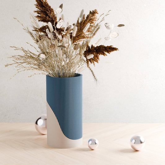 Blue and white vase with dried flowers on a light surface