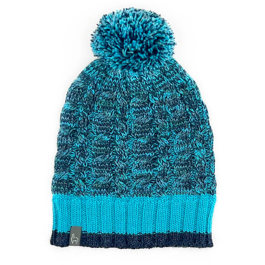 Blue knitted beanie with pom-pom on a white background