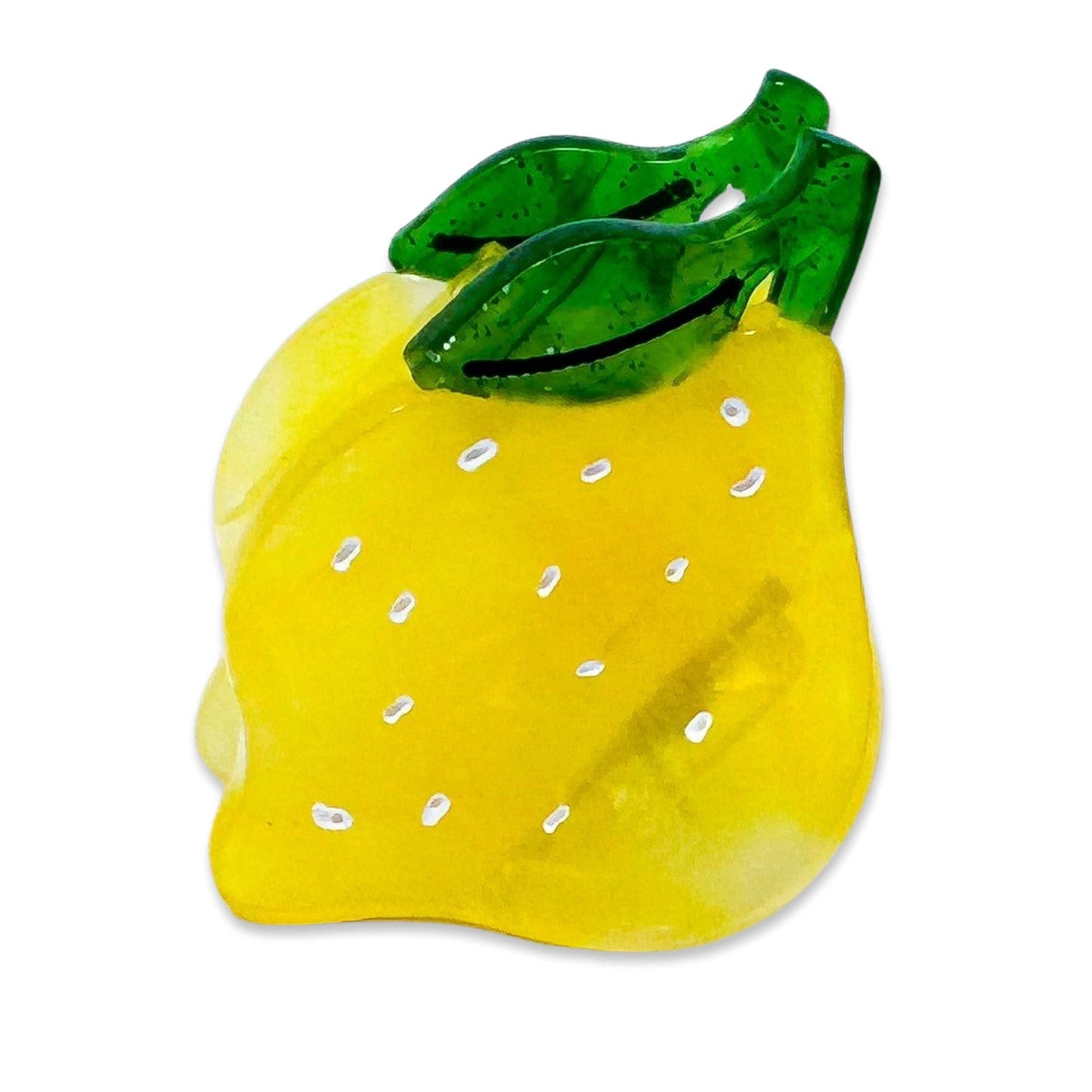 Yellow lemon-shaped object with a green leaf on a white background