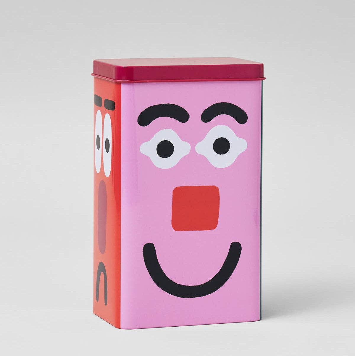 Rectangular tin with a face design on a white background