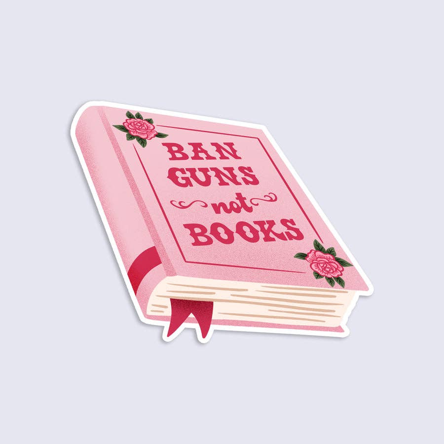 Pink book-shaped sticker with 'Ban Guns not Books' text on a light gray background