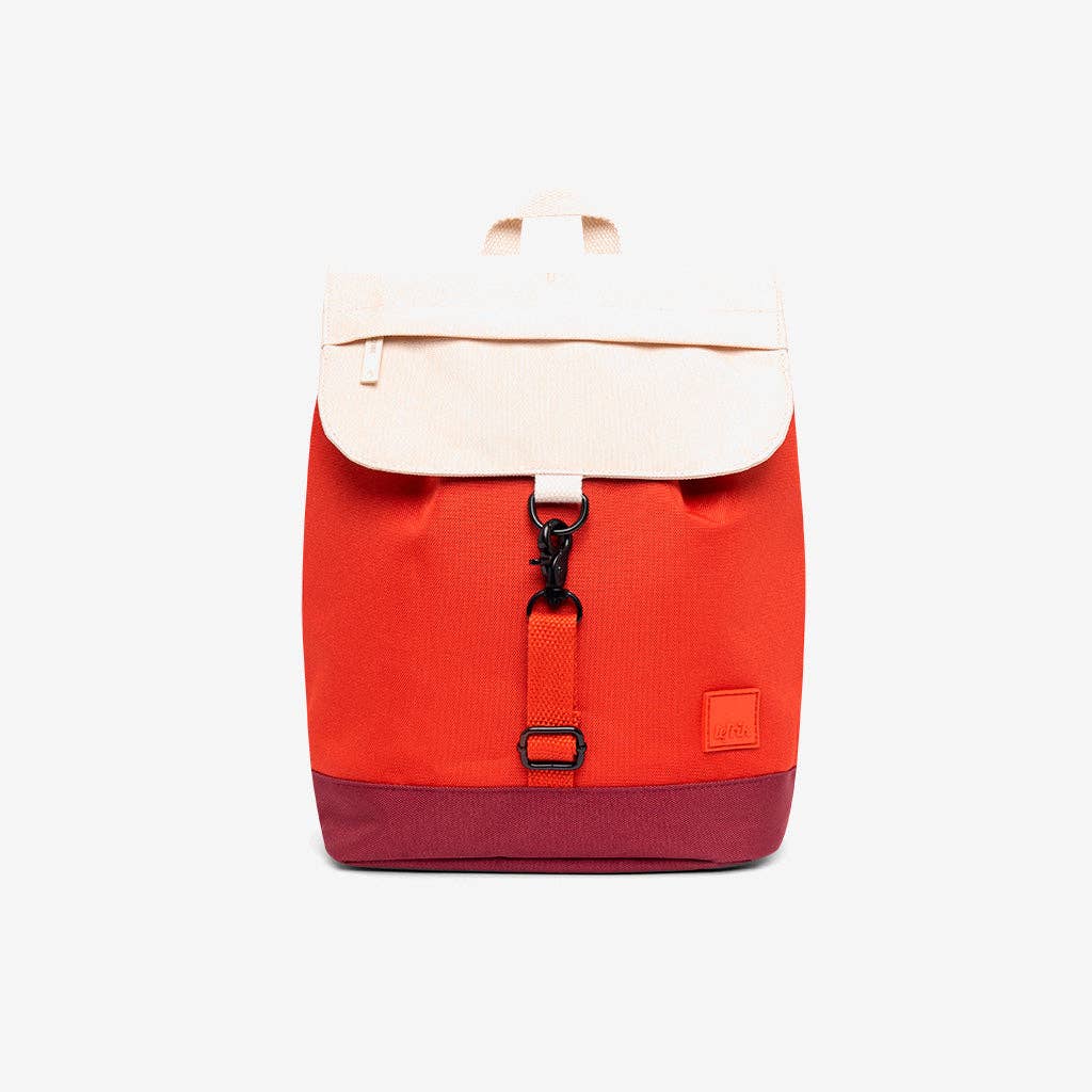 A color-blocked canvas backpack with a bright red body, a cream-colored top flap, and a dark red bottom base, shown against a plain white background.