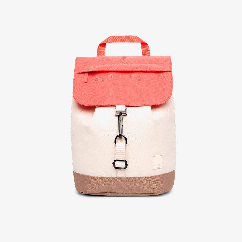 A color-blocked canvas backpack with a coral pink top flap and handle