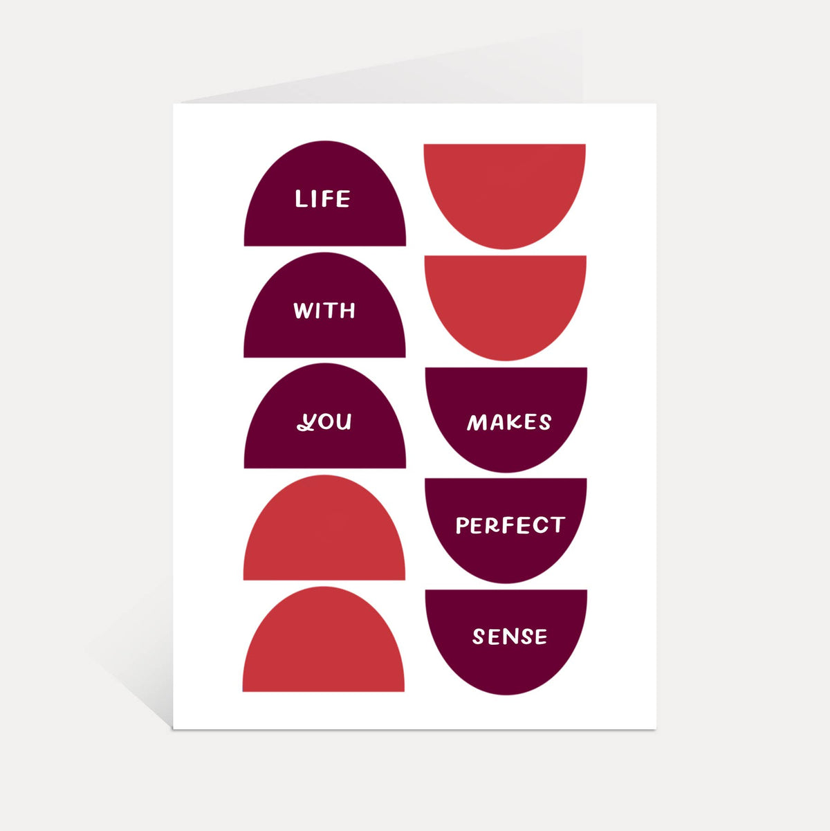 A minimalist art print or card featuring a grid of red and dark magenta semicircles with white text reading 'LIFE WITH YOU MAKES PERFECT SENSE' on a white background.