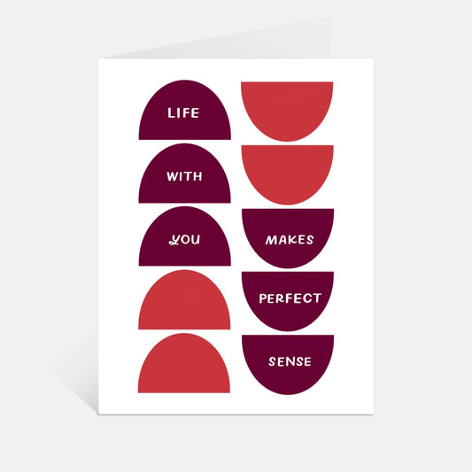 A minimalist art print or card featuring a grid of red and dark magenta semicircles with white text reading 'LIFE WITH YOU MAKES PERFECT SENSE' on a white background.