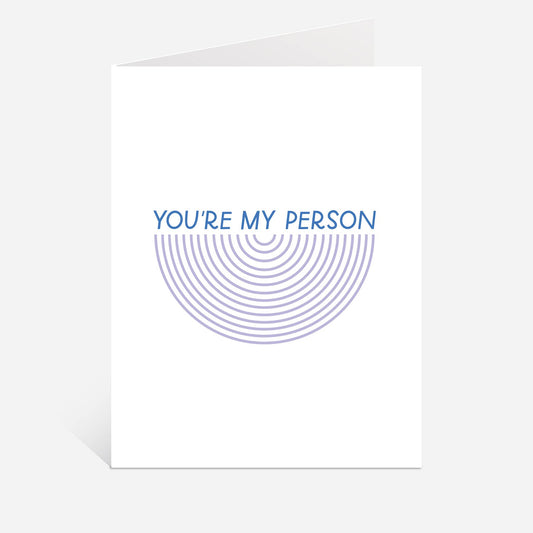 A white greeting card with a blue graphic design that reads 'YOU'RE MY PERSON' above concentric semi-circular lines, shown on a light gray background.