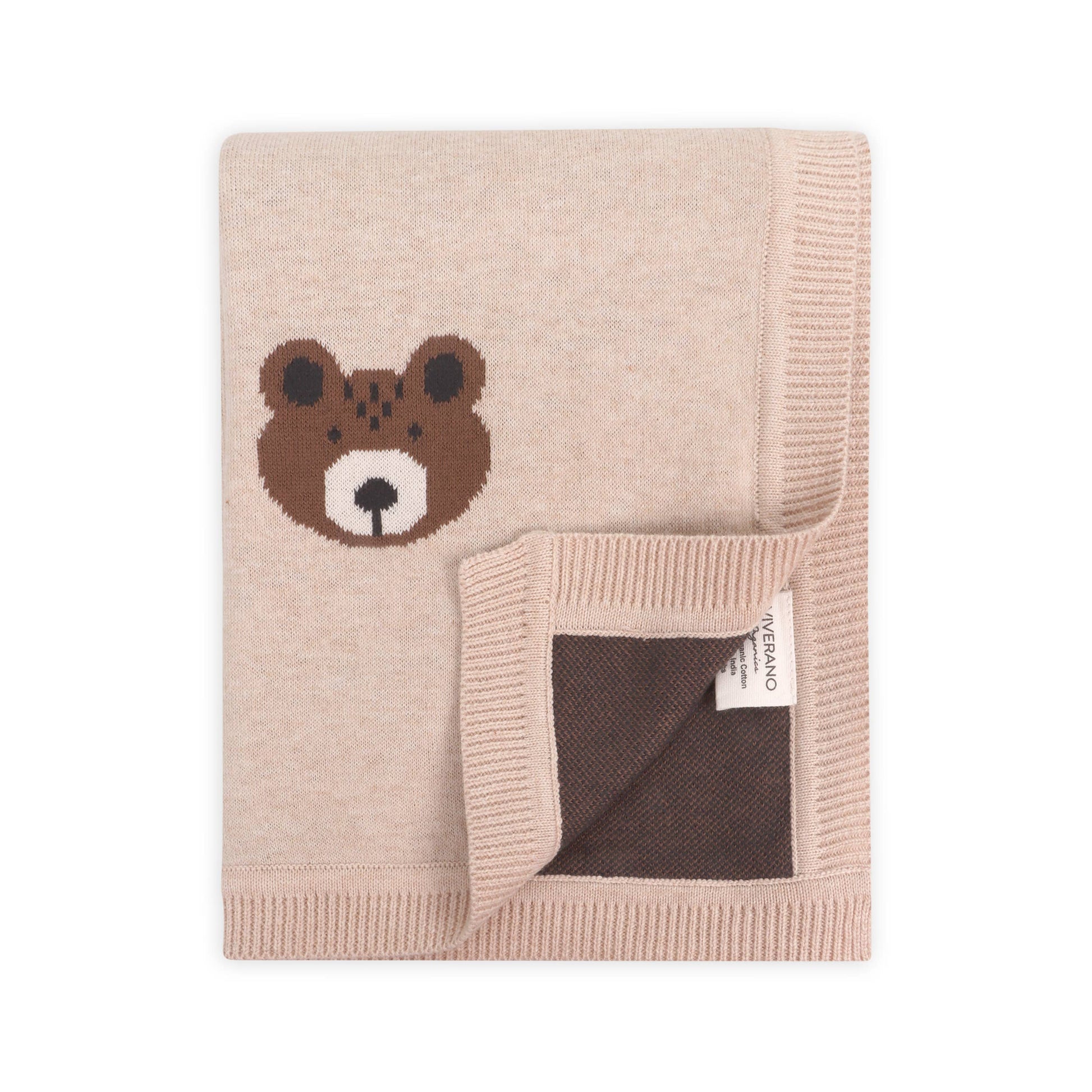Beige knitted blanket with a bear face design on a white background