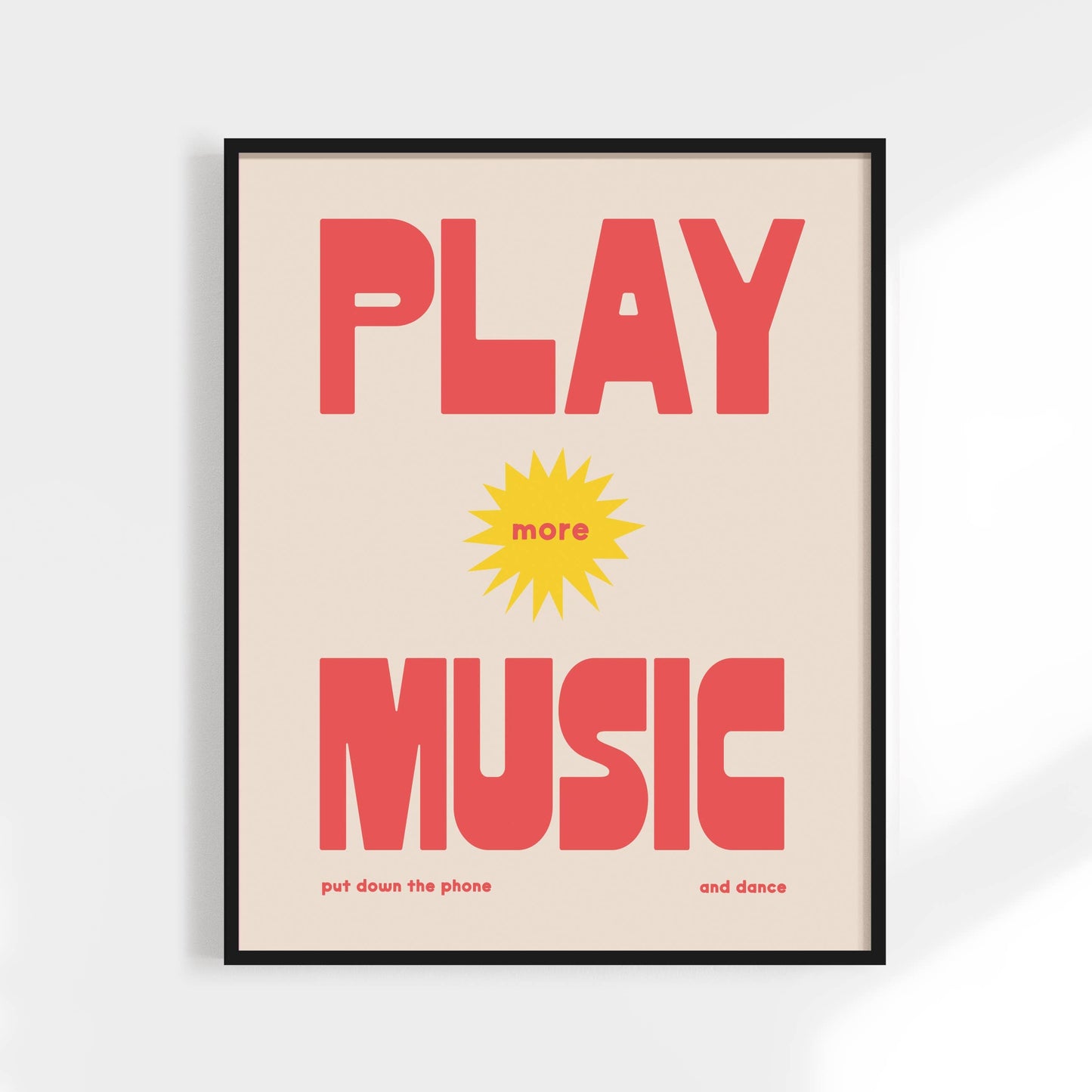 Framed poster with 'Play more music put down the phone and dance' text on a light background