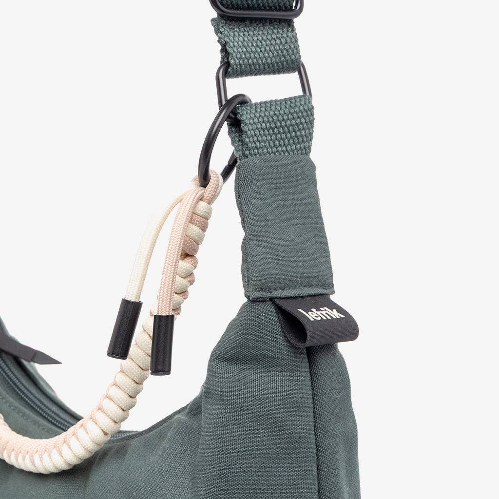 Green handbag with a braided handle on a white background
