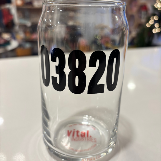Clear glass tumbler with '03820' printed on it, featuring a blurred background.