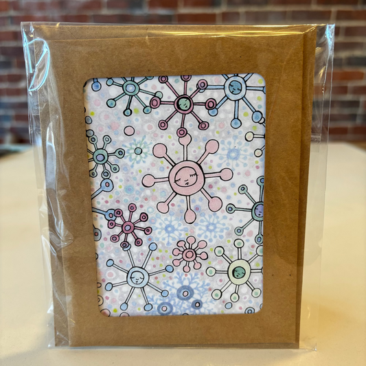Packaged product with a colorful design on a clear plastic cover against a brick wall background