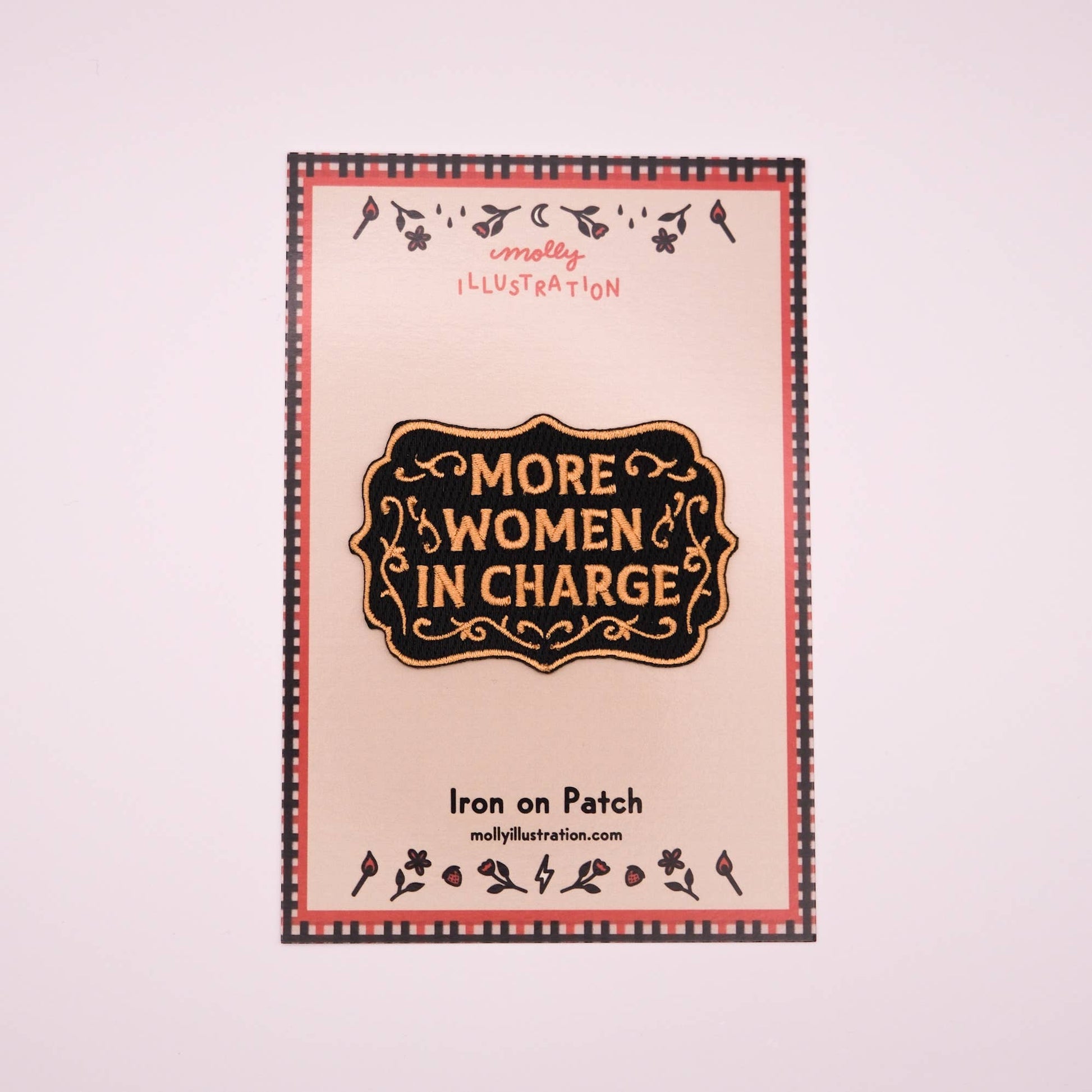 Iron on patch with 'More Women in Charge' text and decorative border on a light pink background