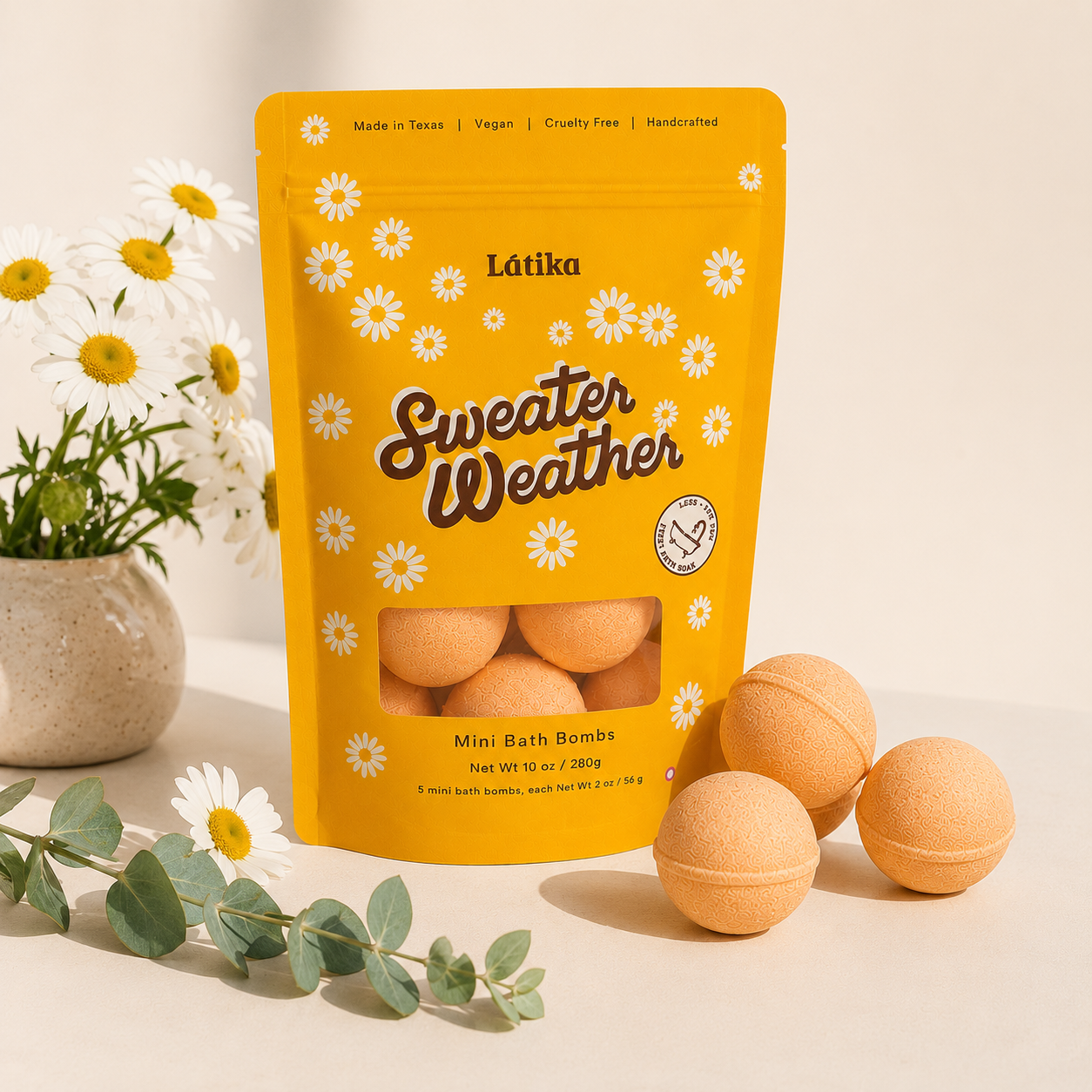 A stand-up pouch of Látika Sweater Weather Mini Bath Bombs in a bright yellow package