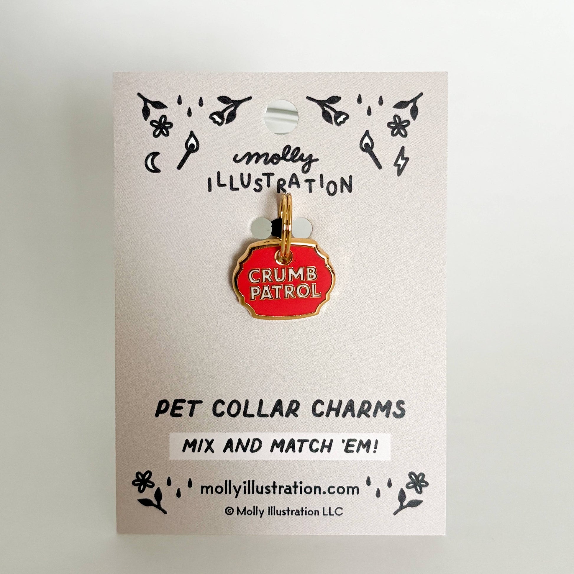 Pet collar charm on a Molly Illustration branded card with 'Crumbs Patrol' design.