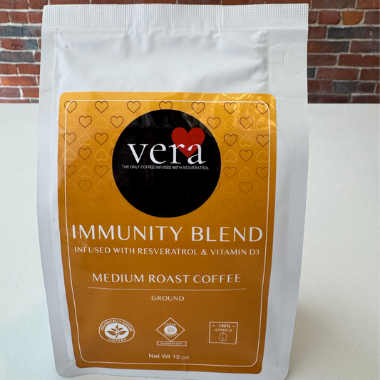 Coffee bag labeled 'Vera Immunity Blend' on a white background with brick wall.