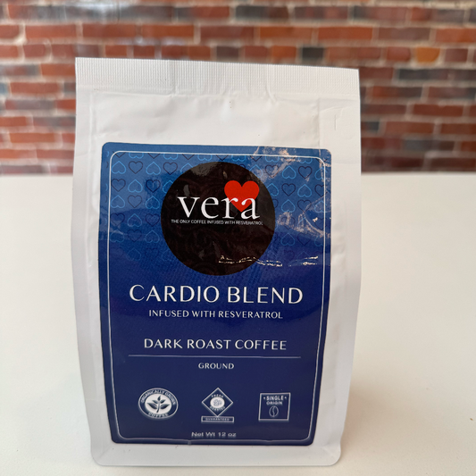 Coffee package labeled 'Vera Cardio Blend' on a white surface with a brick wall background